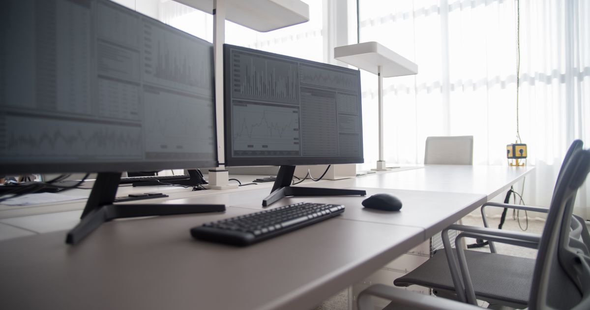 Stylish contemporary office featuring multiple computer monitors and ergonomic chairs.